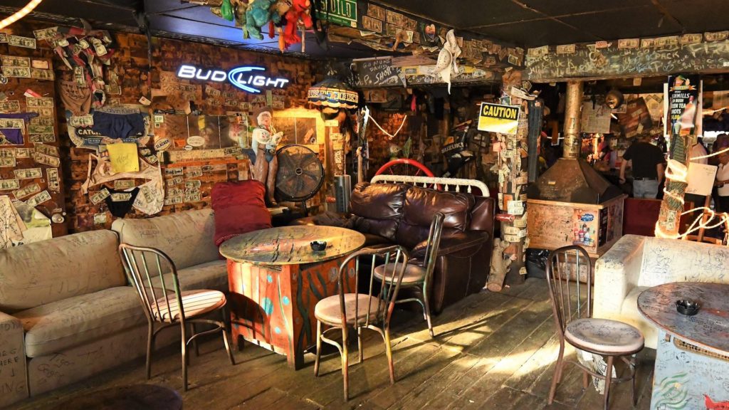 Interior of a Beach Dive Bar with license plates, neon signs and dollar bills stuck to the wall