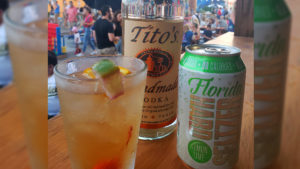 A mixed drink, a bottle of Tito's Vodka, and a can of 3 Daughters Brewing's Florida Hard Seltzer