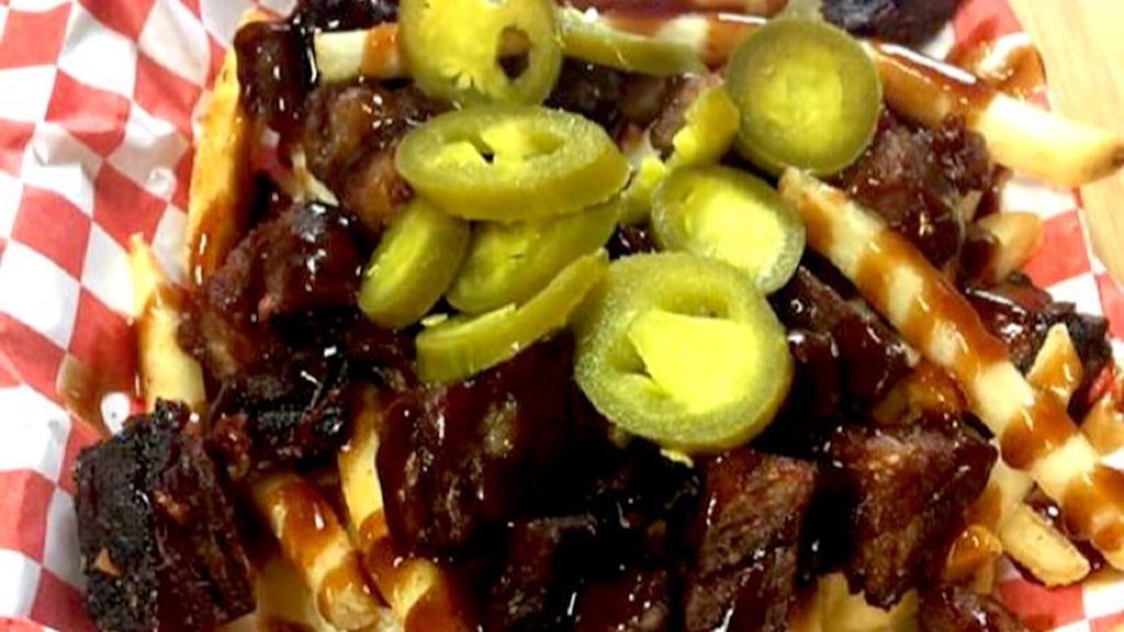 plate of fries covered in ribs and BBQ sauce
