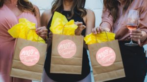 Photo of three paper shopping bags with tissue paper sticking out