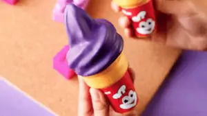 Photo of a purple ube ice cream cone with a red bumblebee logo