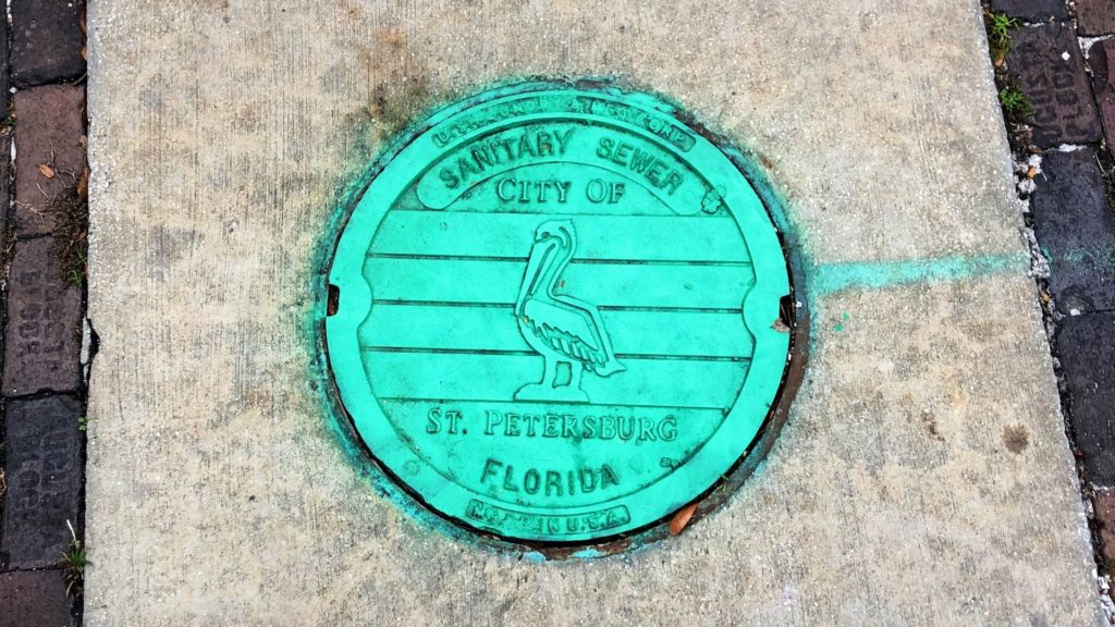 Photo of a bright green manhole cover in downtown St. Petersburg