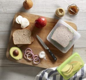 Image of sandwich in a reusable food bag with all the ingredients on the counter