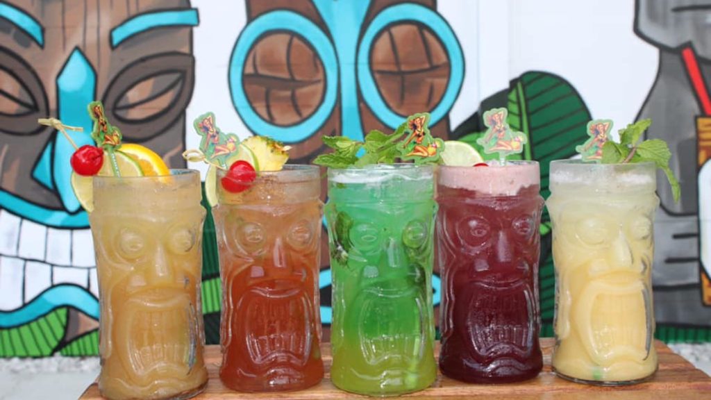 Photo of assorted colorful cocktails in tiki glasses