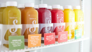 Assorted bottles of cold press juices ranging from green to yellow