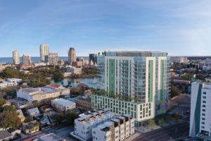 Rendering of a condo tower with a white and green facade overlooking a downtown area