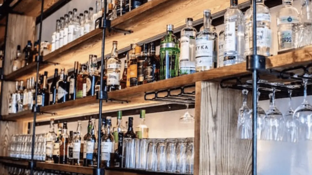 Photo behind a bar featuring liquor bottles