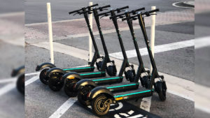 Five e-scooters side by side in a parking spot