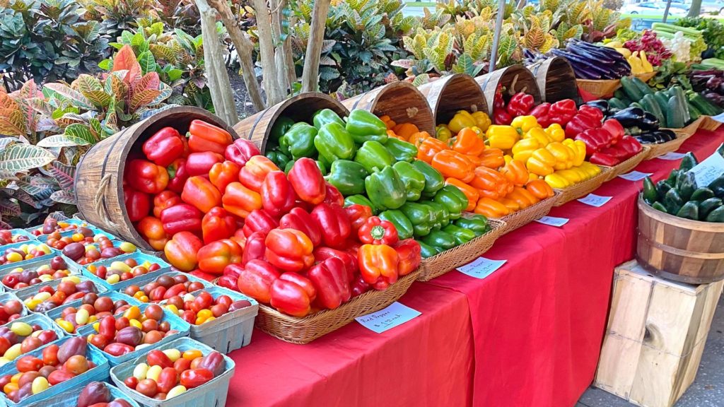 assortment of fruits and veggies on a table at an outdoor market