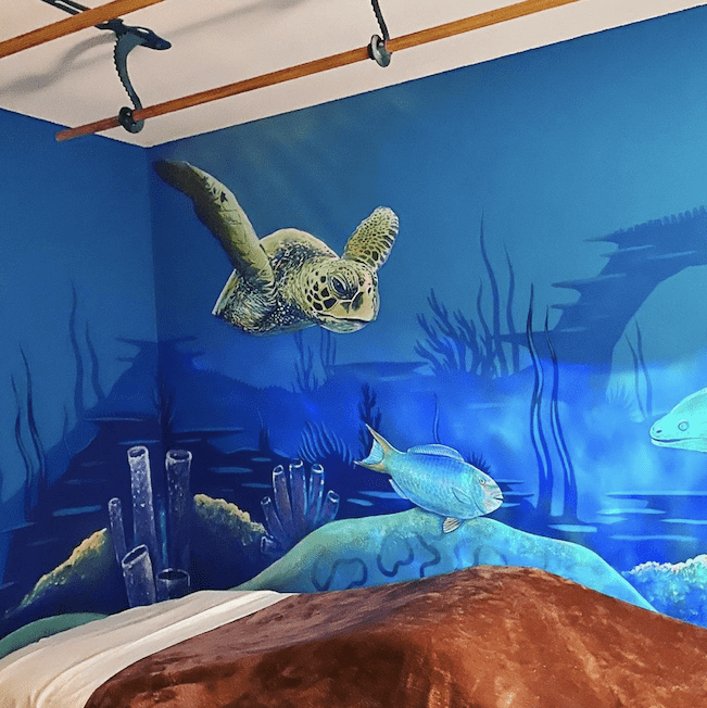 Inside the massage room with an aquatic mural with sea turtles