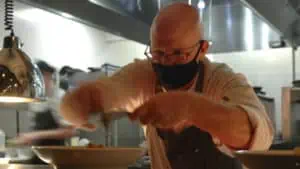 Photo of a chef preparing a dish inside of.a kitchen