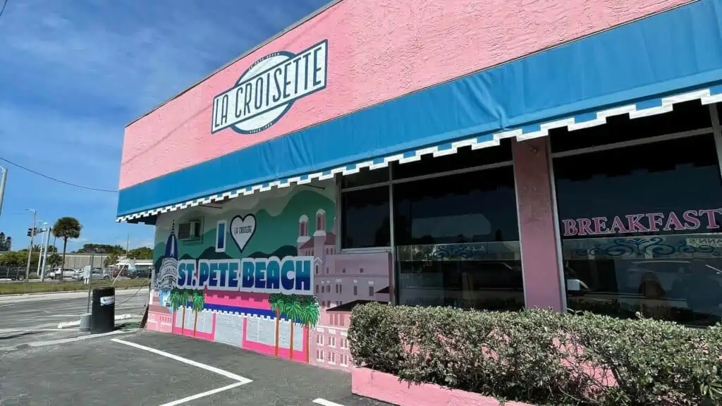 Pink exterior of a breakfast restaurant with the words "I Love St. Pete Beach" painted on the side