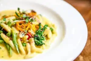 photo of a pasta dish with fresh greens on top