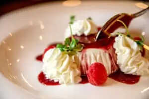 plated dessert with a red sauce poured on top