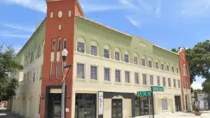 Exterior of an old building with green, pale, and orange bricks