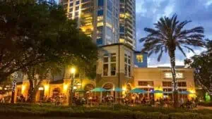 exterior of restaurant with string lights around palm trees out front