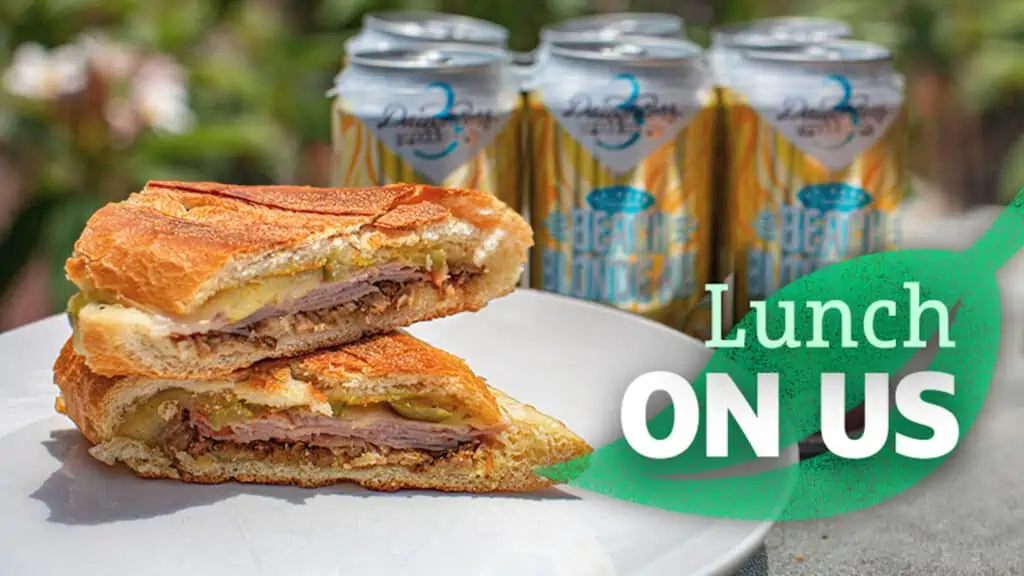 photo of a Cuban sandwich next to a 6 pack of beer