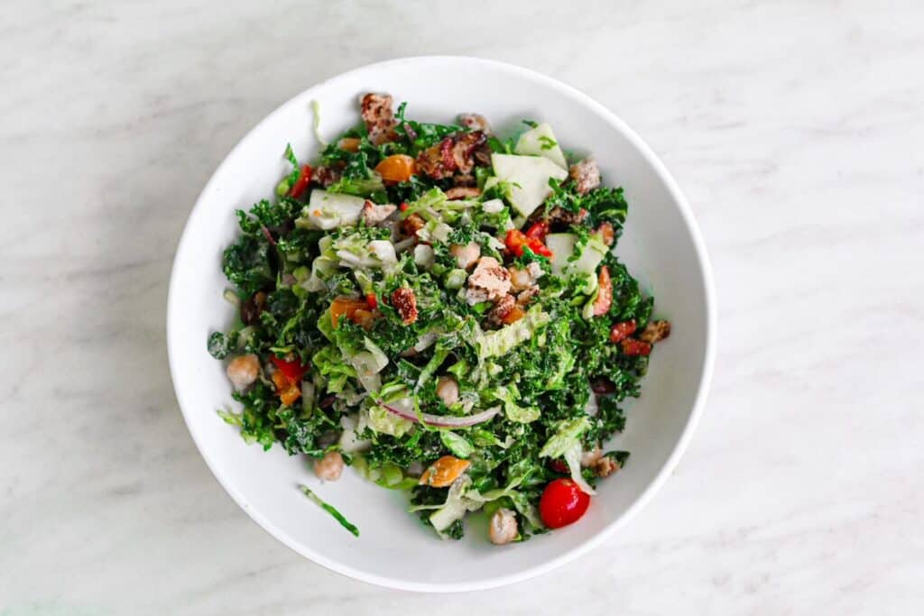 a bowl filled with kale and fresh veggies