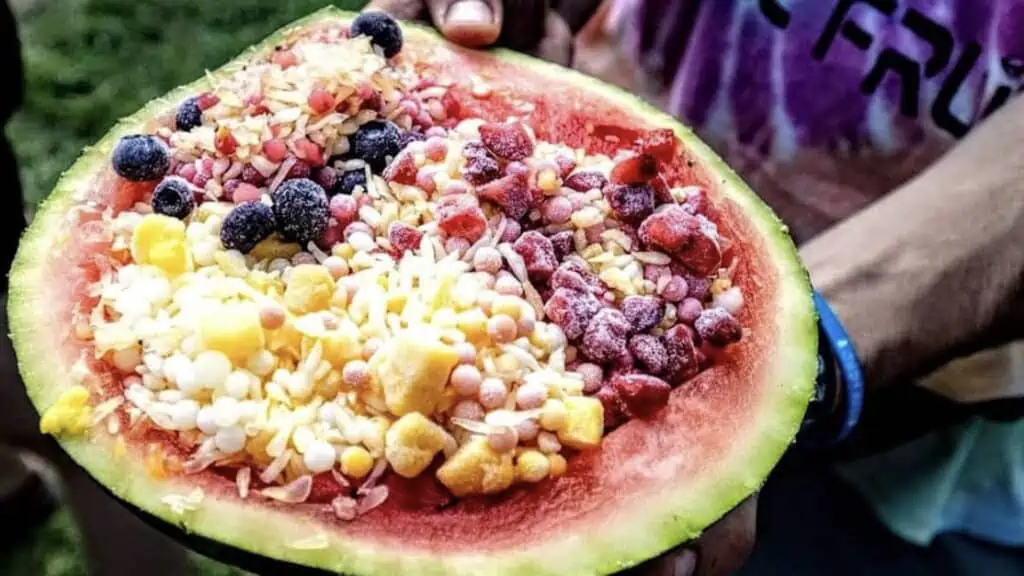 a giant watermelon with fruit pearls stuck in it