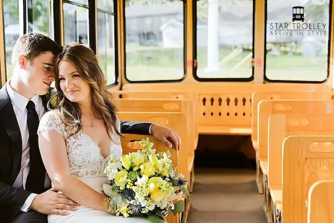 bride and groom sitting beside each other on a trolley