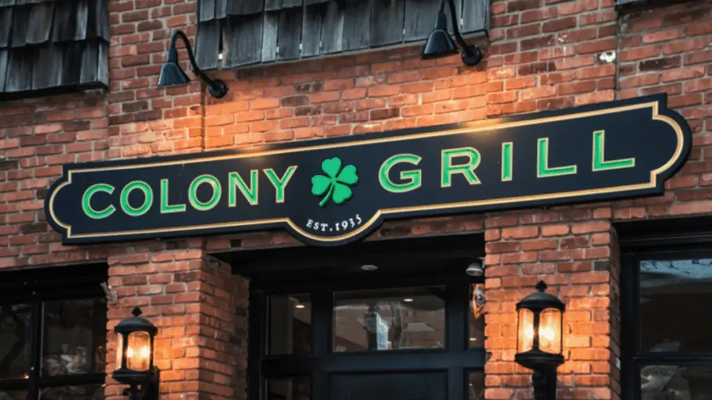 brick exterior with a black and green sign that reads Colony Grill