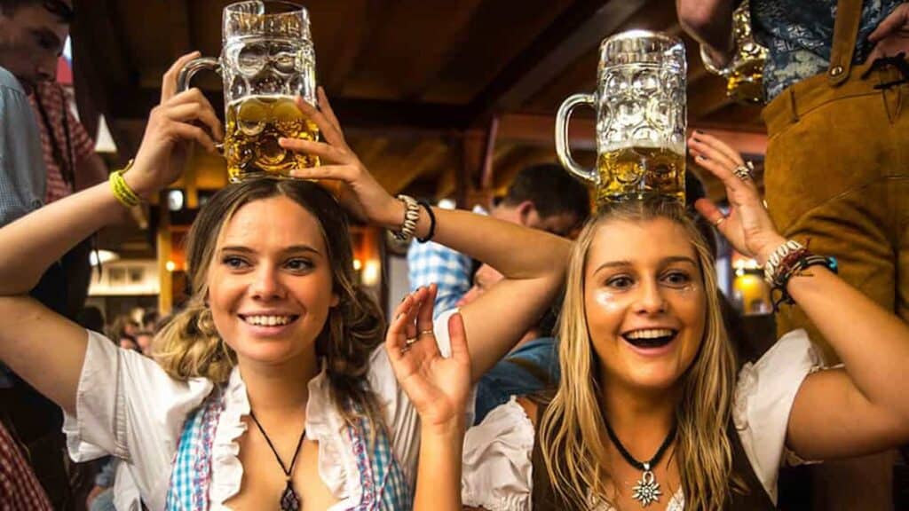 two women with beer glasses balanced on their heads