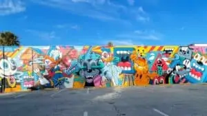 large mural of cartoon characters on side of building near parking lot