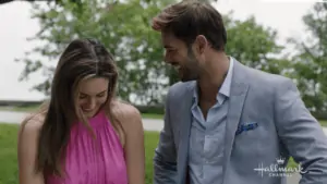 Two people in dress clothes standing in a waterfront park