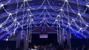 inside an arts venue with string lights hanging from a blue ceiling