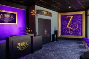 inside a lobby with purple walls and a golden Z at the far end