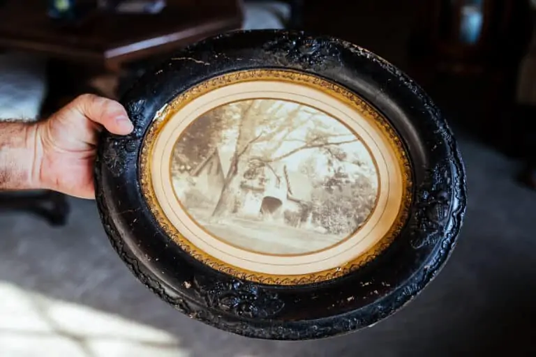 a photo in an oval frame featuring a historic cottage
