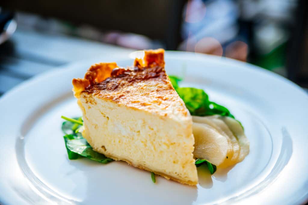 A slice of goat cheese tart on a plate