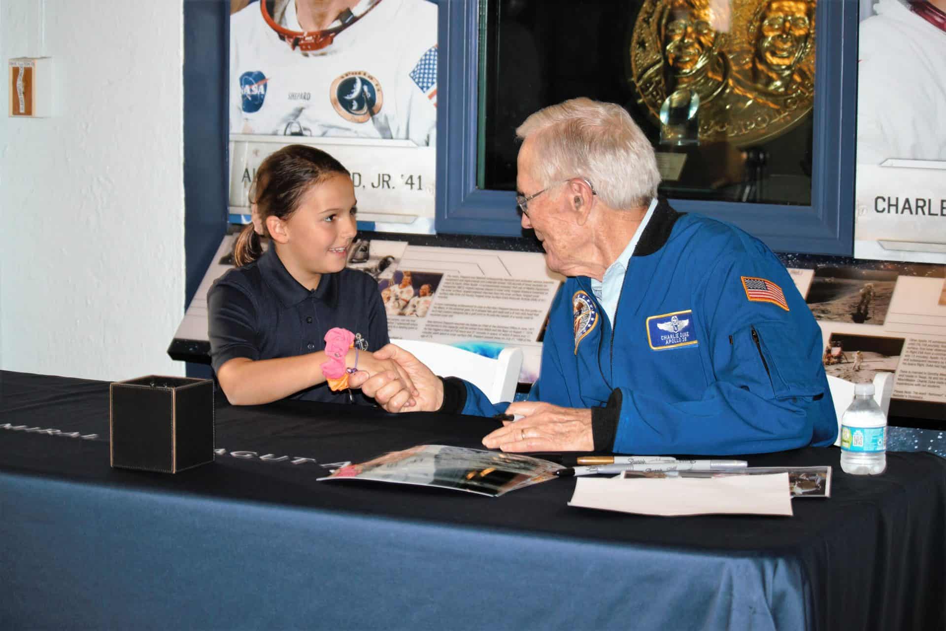 A lower school student meeting astronaut and AFA graduate Charlie Duke