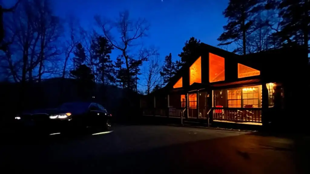 Night shot of Airbnb log cabin in North Carolina with car parked in front