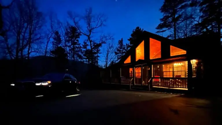 Night shot of Airbnb log cabin in North Carolina with car parked in front
