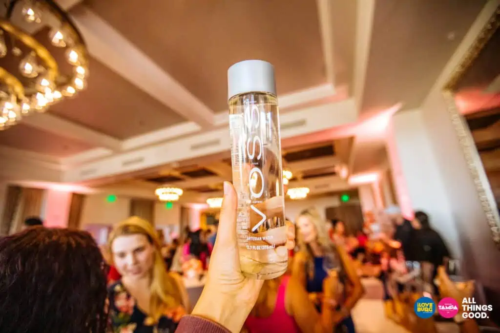 a bottle of VOSS water held in the air