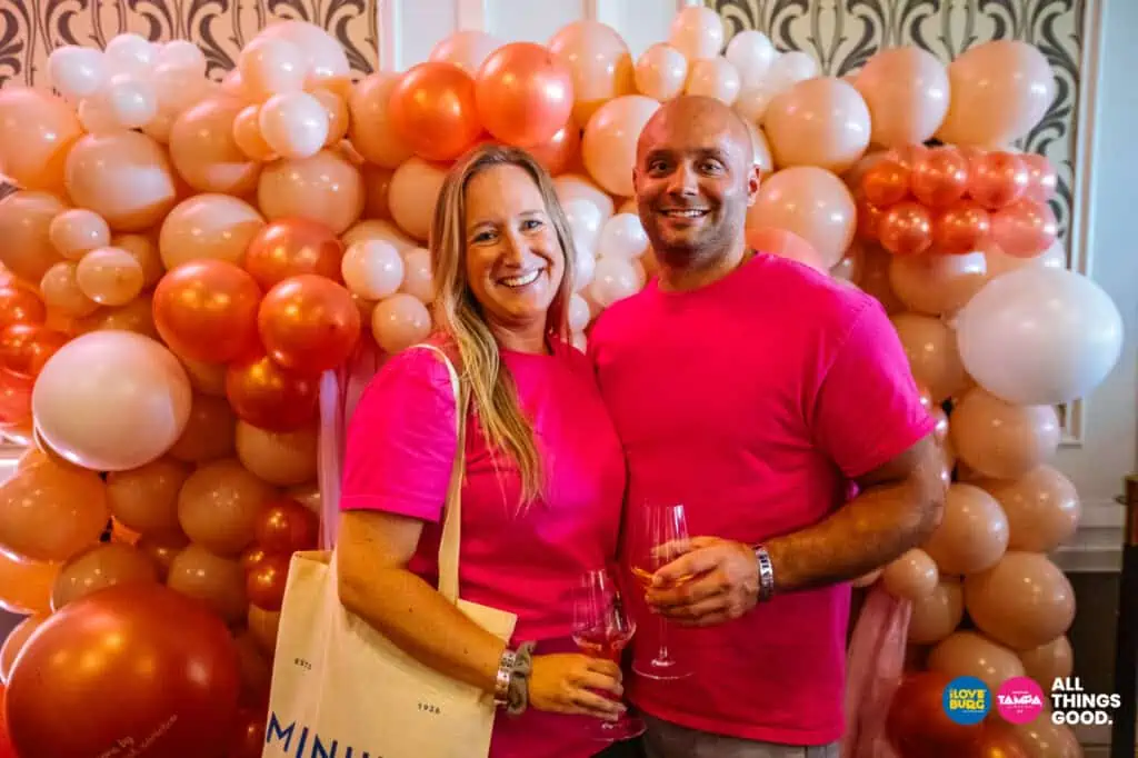 the owners of suncoast social co pose in front of their balloon wall