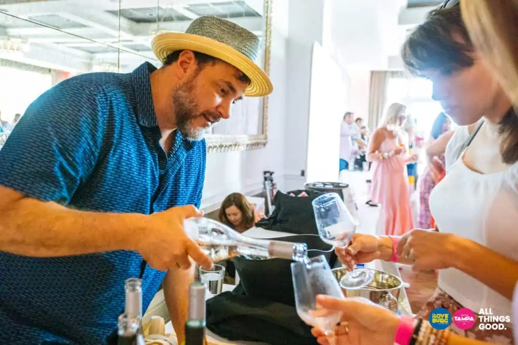 a wine vendor pours a glass of wine for a guest