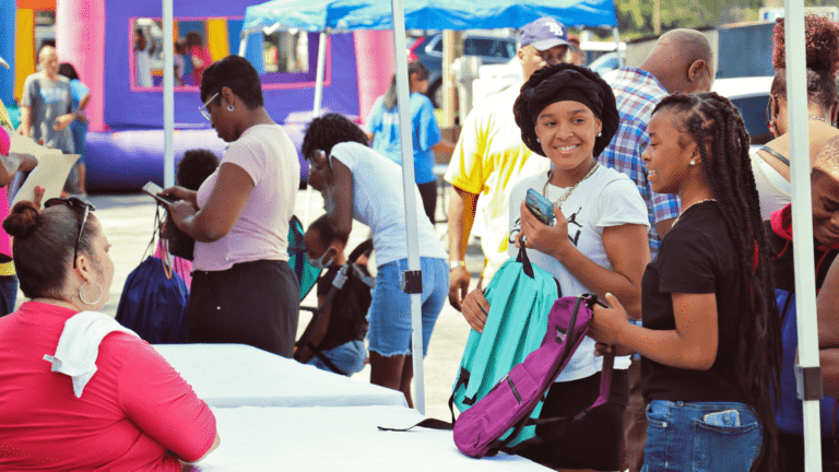 Students picking up backpacks at a giveaway