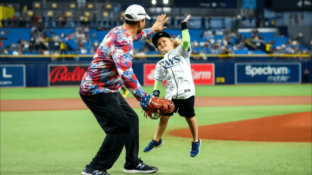 A Rays player and a kid high-fiving