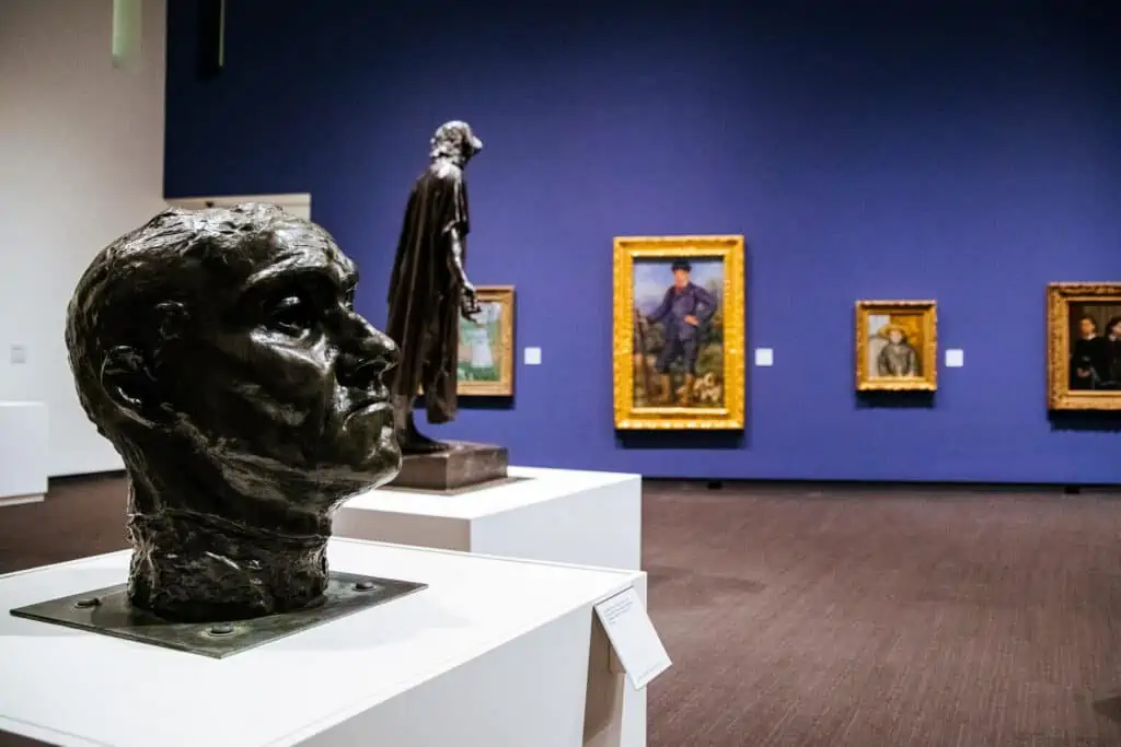 Sculptures by Rodin in front of impressionist paintings