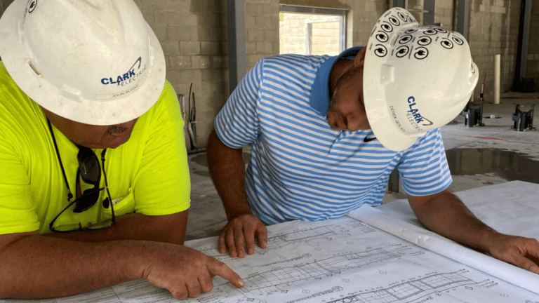 Two on-site engineers reviewing electrical plans