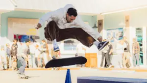 a person leaps over a rail as a skateboard spins under his legs