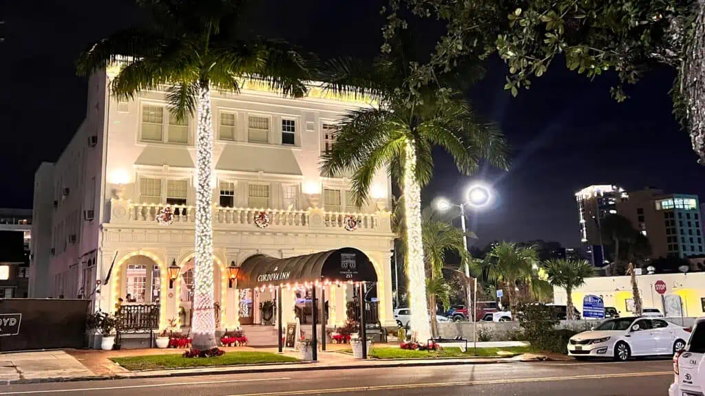 The front facade of the Cordova Inn lit up during the evening