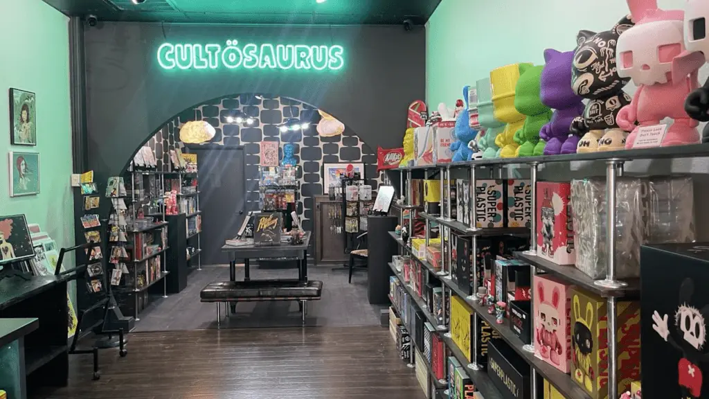 inside a designer toy store with a neon sign in the back.