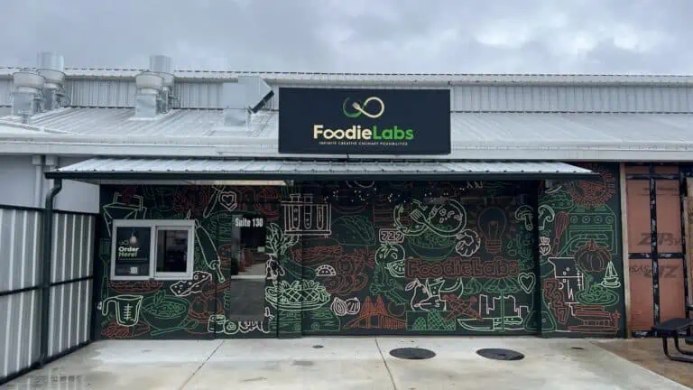 Outside of building with food mural and sign reading Foodie Labs