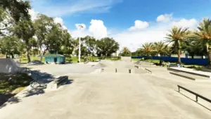 Large concrete skatepark with multiple ramps and rails.