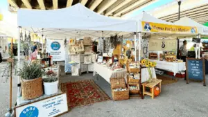 Two vendor tents under a bridge at a large flea market