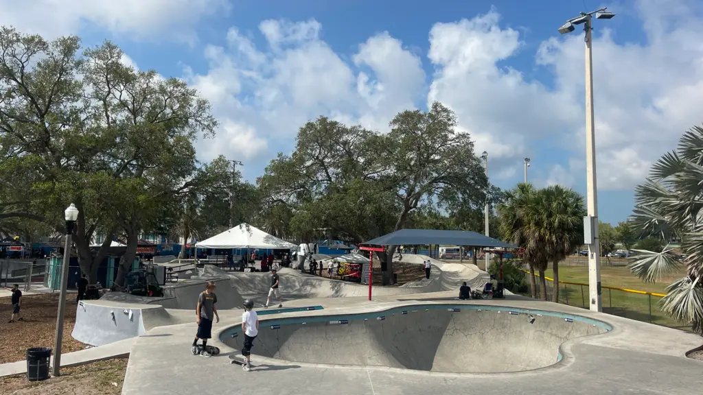 Skateboarders ride ramps at a large outdoor skatepark