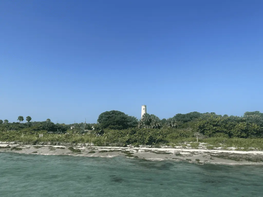 approaching an island park with a lighthouse visible from among palm trees